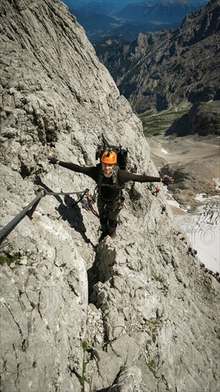 Tourist with equipment on the via ferrata trail in the alps. Zugspitze massif