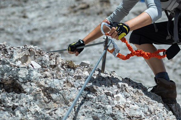 Climbing along a steel line on the via ferrata route in the dolomites. Dolomites