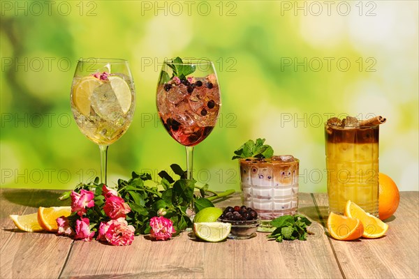 Set of multicolored summer refreshing soft drinks on wooden table with ingredients