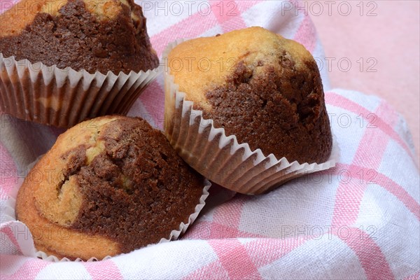 Chocolate muffins in kitchen towel