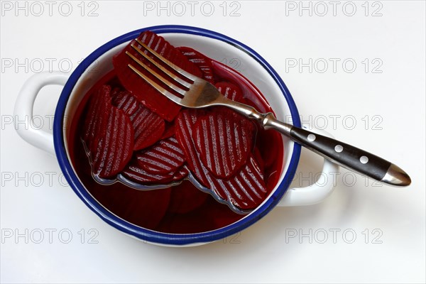 Sliced pickled beetroot with peel and fork