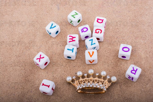 Golden color crown model in front of the letter cubes