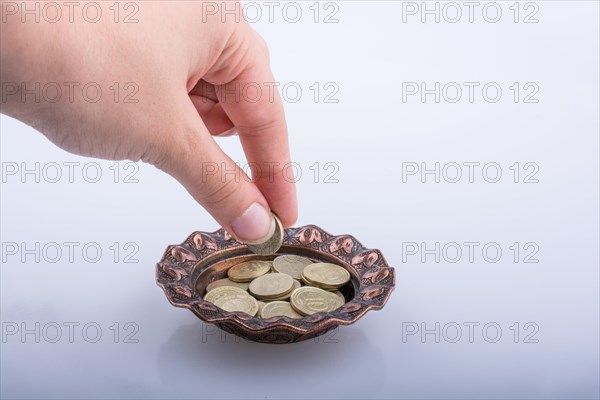 Hand giving away money to a metal bowl