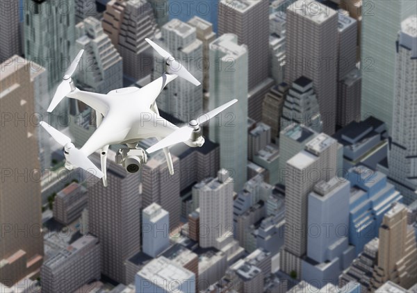 Unmanned aircraft system quadcopter drone in the air above city and corporate buildings