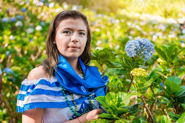 Portrait of smiling woman in national folk costume in a field of flowers. Nicaraguan national folk costume
