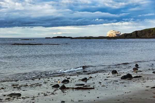 Coastline with beach and bird cliff Bass Rock on the horizon