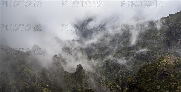 Steep cloudy mountain landscape with rock formations