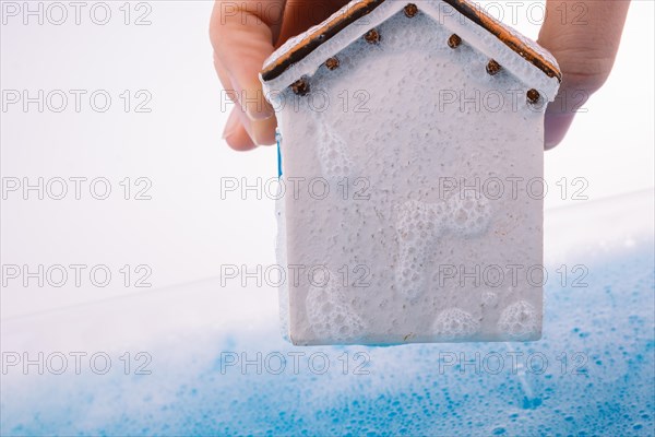 Little model house and a painting brush in foamy water