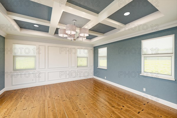 Beautiful blue-gray custom master bedroom complete with entire wainscoting wall