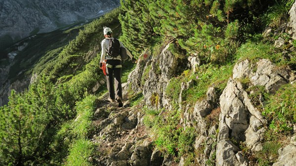 Tourist with equipment on a mountain trail in the Alps. Zugspitze massif