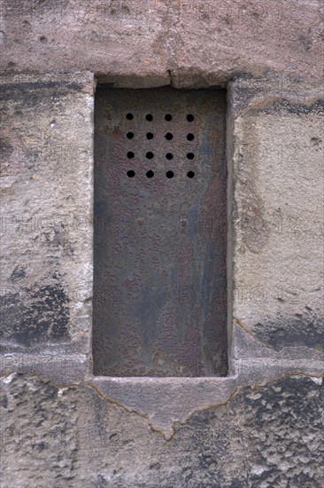 Historic iron peep window on the sacristy