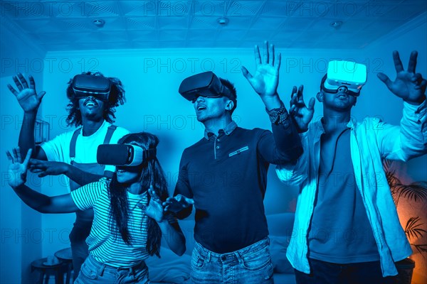 Group of young people in vr glasses in a virtual reality game in a blue light
