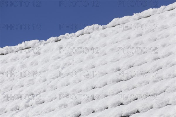 Snowy roof tiles on a roof in winter