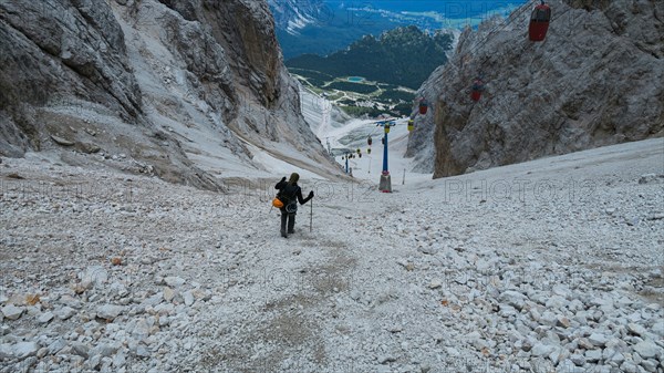 Tourist from the inventory trail in the gully with the gondola lift to Forcella Staunies