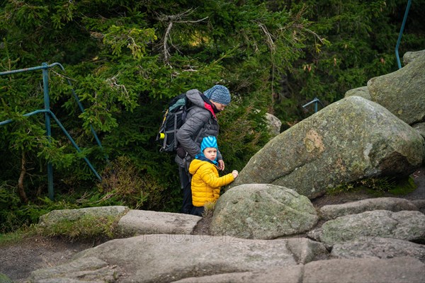 Mum and her little son go on a mountain trail in wet autumn weather. Polish mountains