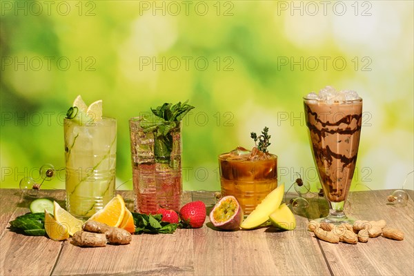 Set of multicolored summer refreshing soft drinks on wooden table with ingredients