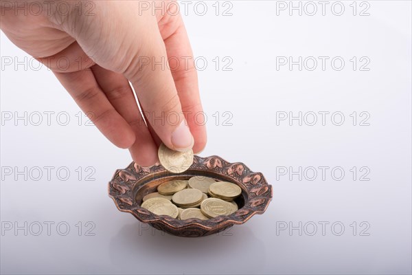 Hand giving away money to a metal bowl