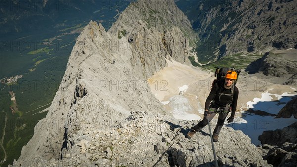 Tourist with equipment on the via ferrata trail in the alps. Zugspitze massif