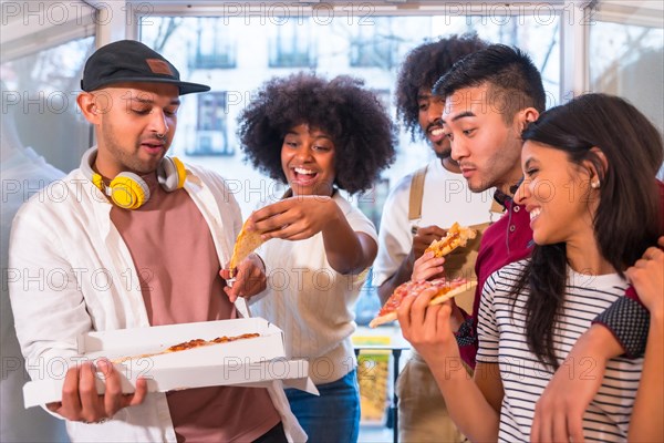 Portrait of a group of friends eating pizza on the terrace at home