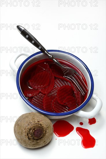 Sliced pickled beetroot with peel and fork