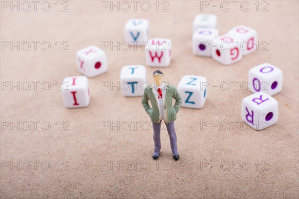 Figurine standing in front of the colorful alphabet letter cubes