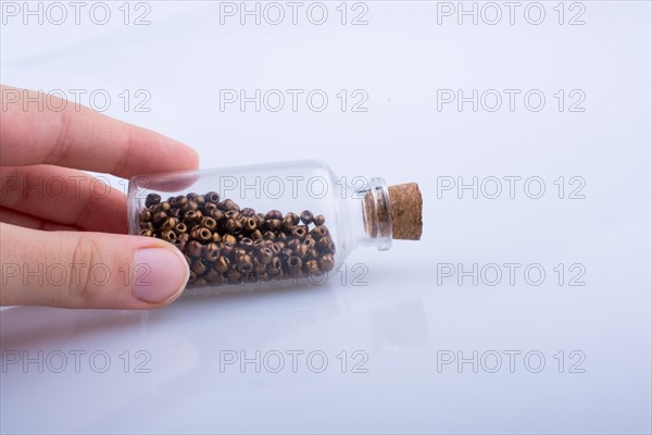 Little perfume glass bottle in hand on a white background