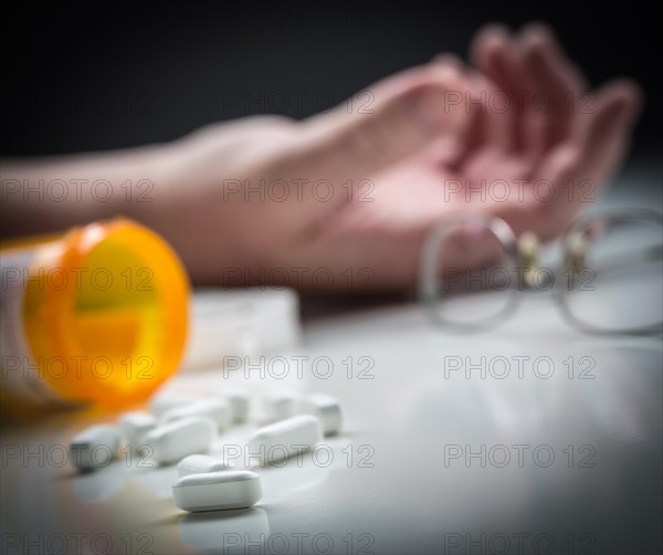 Man passed out on floor behind scattered drugs and medicine bottle