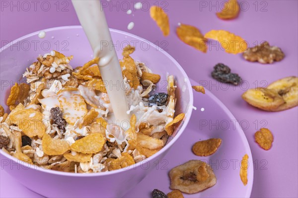 Milk is poured into purple bowl with cereal