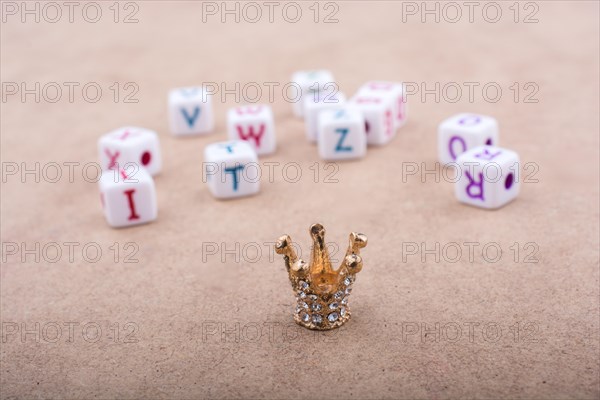 Golden color crown model in front of the letter cubes