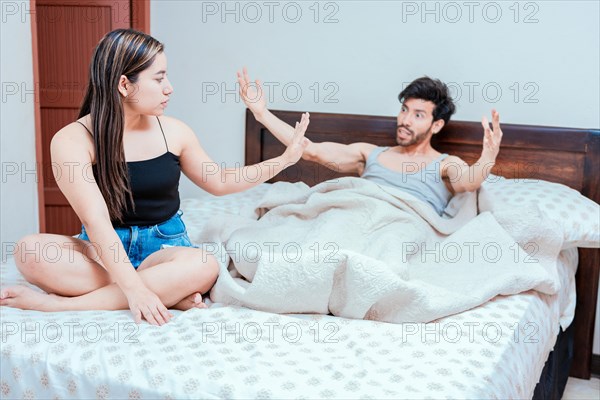Upset woman with husband in bedroom bed