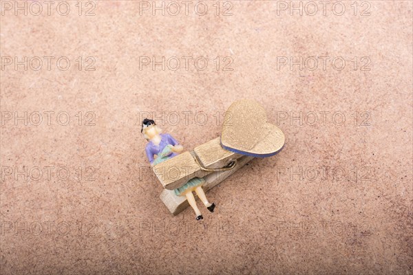 Woman figurine trapped in a clothespin on ground