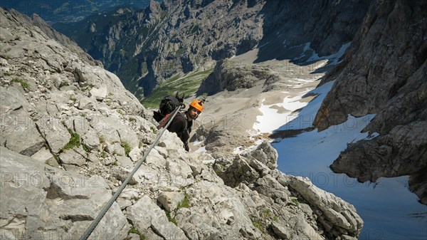 Tourist with equipment on the via ferrata trail in the alps. Zugspitze massif