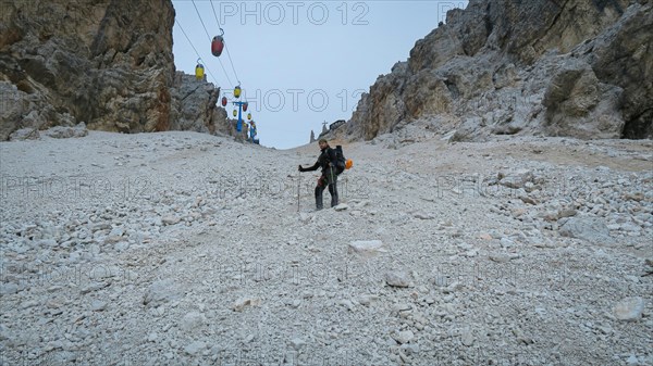 Tourist from the inventory trail in the gully with the gondola lift to Forcella Staunies