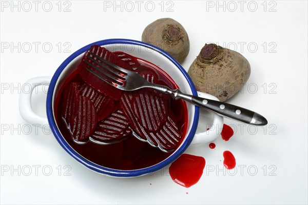 Sliced pickled beetroot with peel and fork