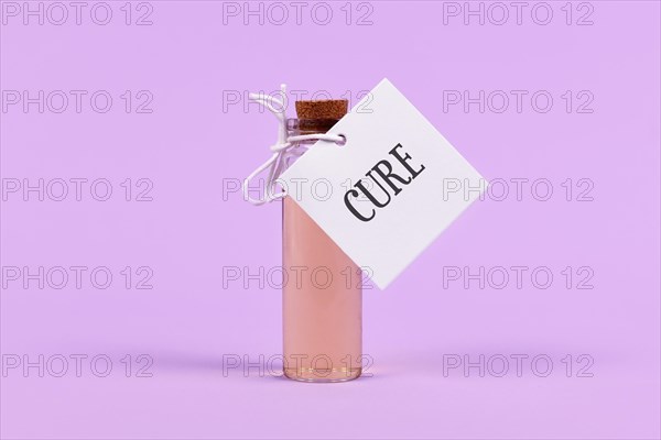 Cure in glass vial with label on violet background