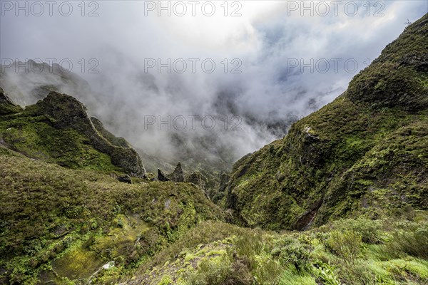 Steep cloudy mountain landscape with rock formations