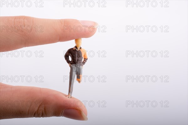 Little man figure with a crippled leg in hand on a white background