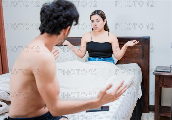 Upset wife with husband in bedroom bed