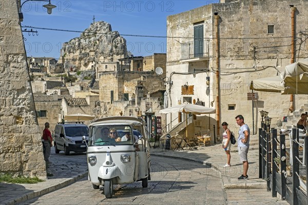 Tourists in tuk-tuk visiting the Sassi di Matera complex of cave dwellings in the ancient town of Matera