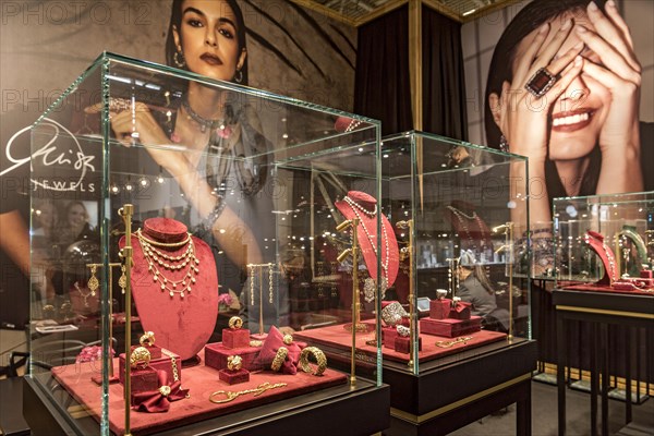 Showcases with high quality jewellery in front of photo wall with elegant woman