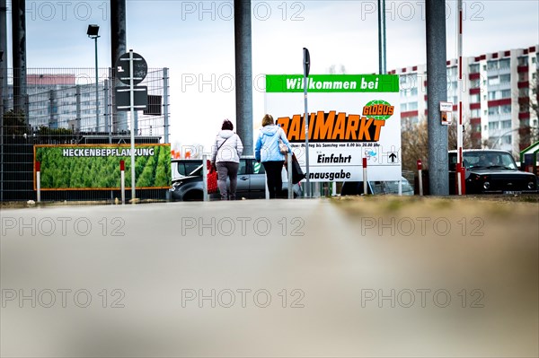 Two woman at the entrance of a Globus DIY store in a commercial area in Berlin