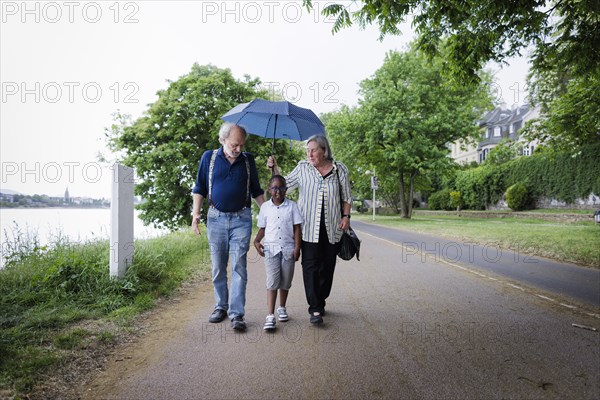 Temporary grandparents. Elderly couple volunteer to look after a boy from Africa for a few hours a week.