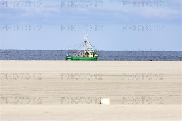 Crab cutter on the North Sea coast and sandy beach at low tide