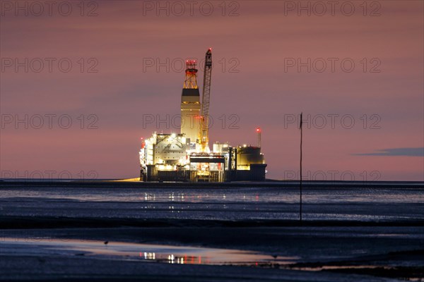 Germanys only oil rig Mittelplate at night and low water