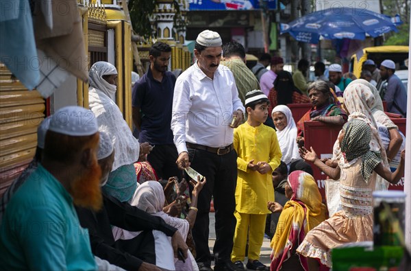 Indian Muslims person give money to needy people after perform the second Friday prayer in the holy month of Ramadan at a Mosque in Guwahati