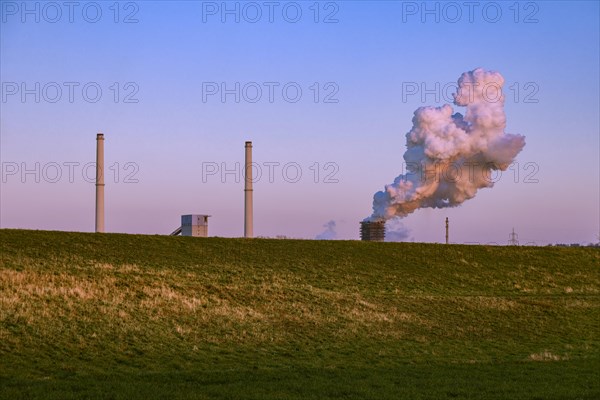 Behind the dyke and the Rhine the chimneys of the industrial landscape of Thyssenkrupp Steel Europe AG