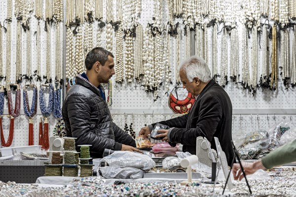 Men paying in cash at trade fair stand for minerals