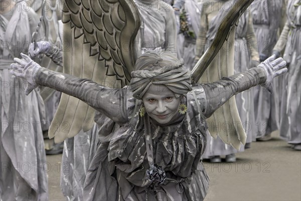 Young smiling woman with wings in grey