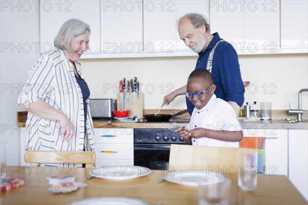 Temporary grandparents. Elderly couple volunteer to look after a boy from Africa for a few hours a week