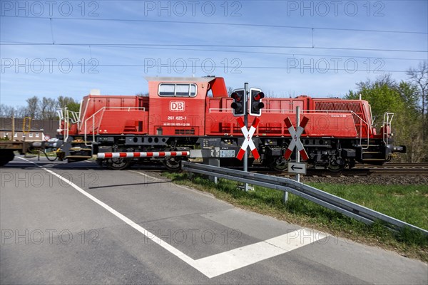 Passing goods train with locomotive Gravitation 10 BB at level crossing